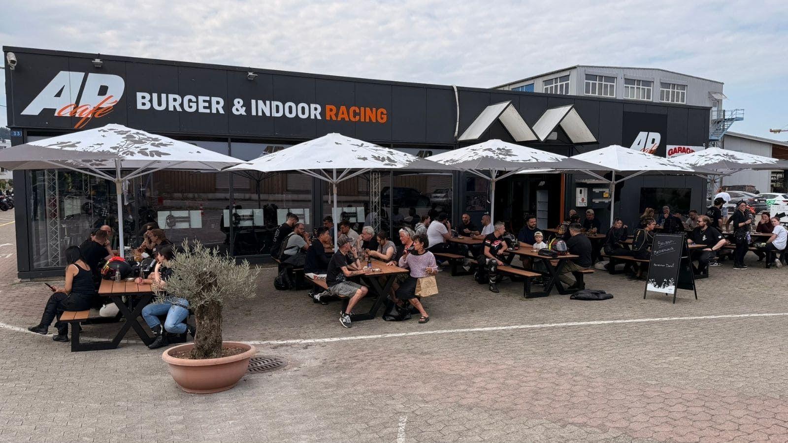 Die volle Sommer Terrasse mit glücklichen Gästen vom AP Café Indoor-Racing in Aadorf, Thurgau.