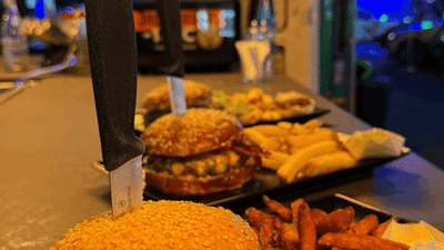 Frisch zubereiteter Burger mit Süsskartoffel-Pommes, serviert im AP Café INDOOR-RACING in Aadorf
