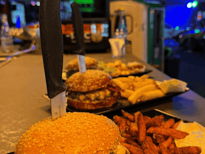 Frisch zubereiteter Burger mit Süsskartoffel-Pommes, serviert im AP Café INDOOR-RACING in Aadorf