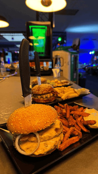 Frisch zubereiteter Burger mit Süsskartoffel-Pommes, serviert im AP Café INDOOR-RACING in Aadorf