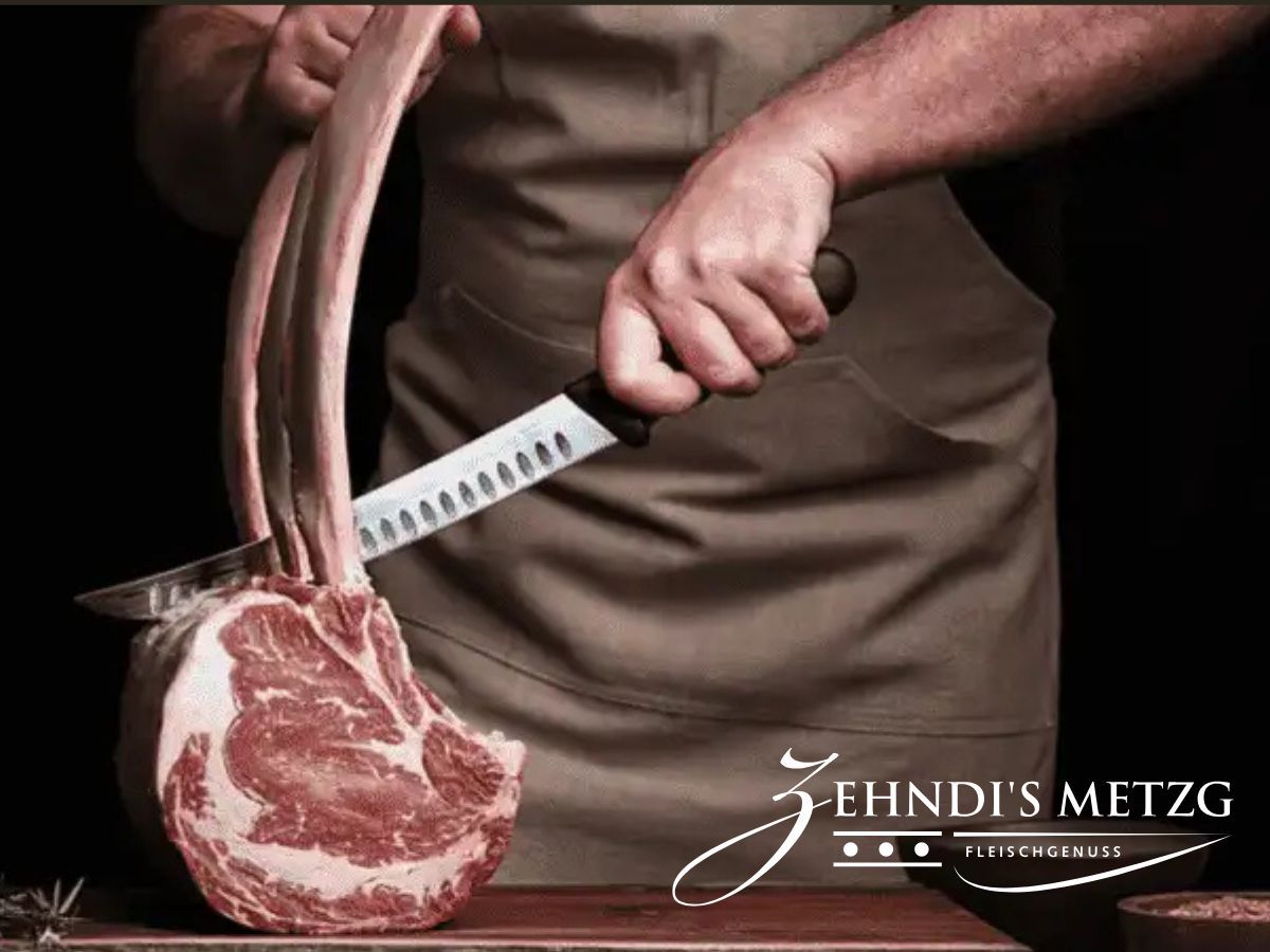 Metzger von Zehndi's Metzg schneidet ein Tomahawk-Steak mit dem Messer zu, im Vordergrund die marmorierte Fleischmaserung — hier kommt das Schweizer Fleisch für unsere Burger her