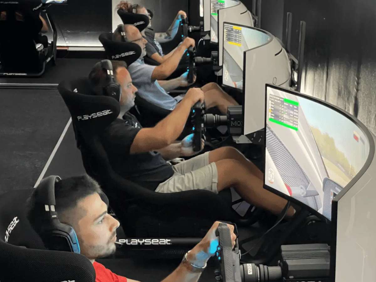 Innenaufnahme des Centers in Aadorf: eine Reihe Playseat-Rennsimulatoren, Fahrer sitzen an den Lenkrädern vor gebogenen Bildschirmen