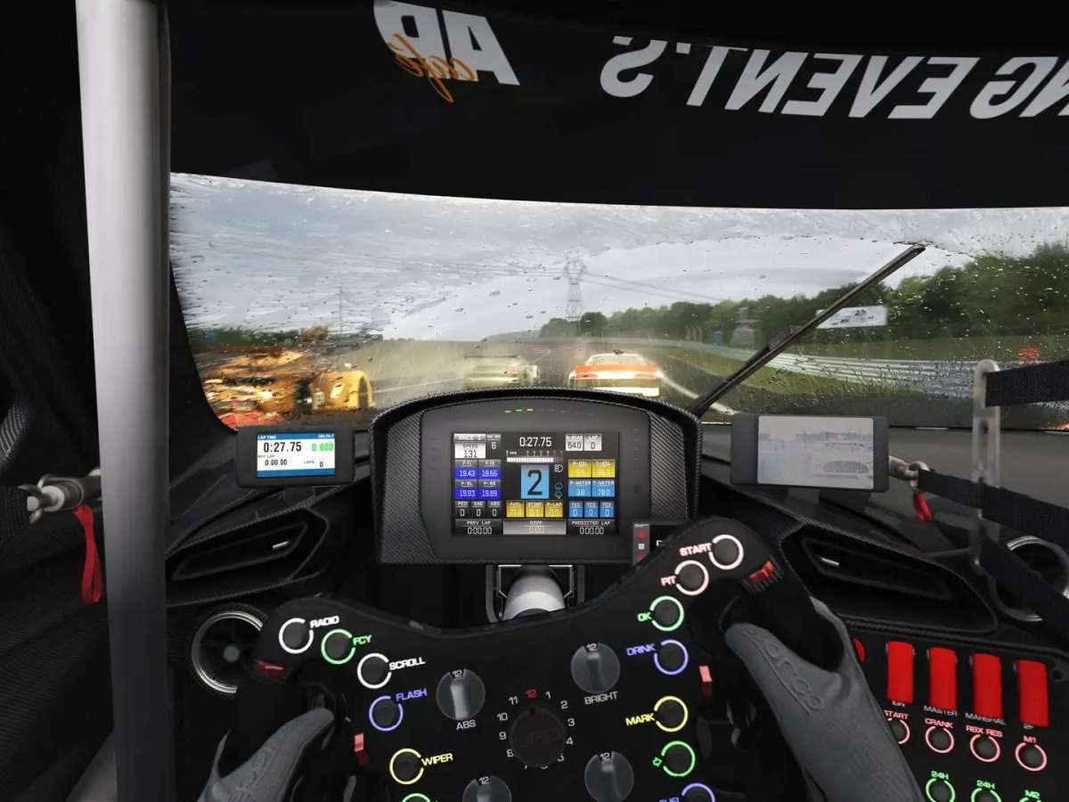 Blick aus dem Cockpit eines Rennwagens bei Regen: beleuchtetes Renn-Lenkrad, laufender Scheibenwischer, nasse Strecke mit Gischt der vorausfahrenden Fahrzeuge