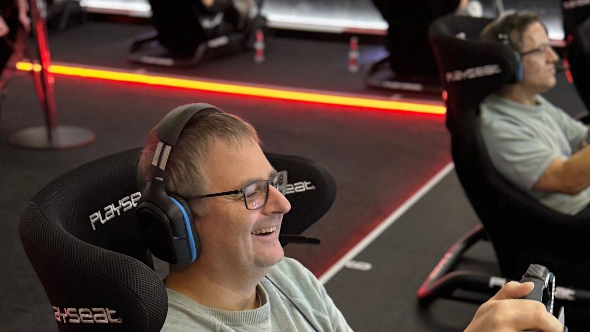 Fahrer lacht begeistert am Lenkrad — der Wow-Moment beim Sim Racing