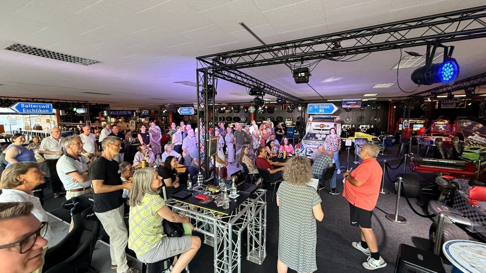 Grosse Firmengruppe verfolgt das Fahrer-Briefing vor dem Teamevent im Indoor-Racing Center Aadorf