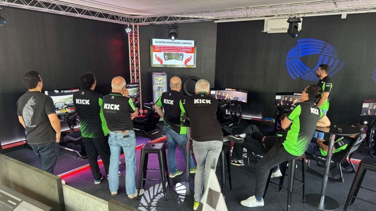 Teilnehmende eines Teamevents bei der Einführung zur Lenkrad-Bedienung vor dem ersten Rennen