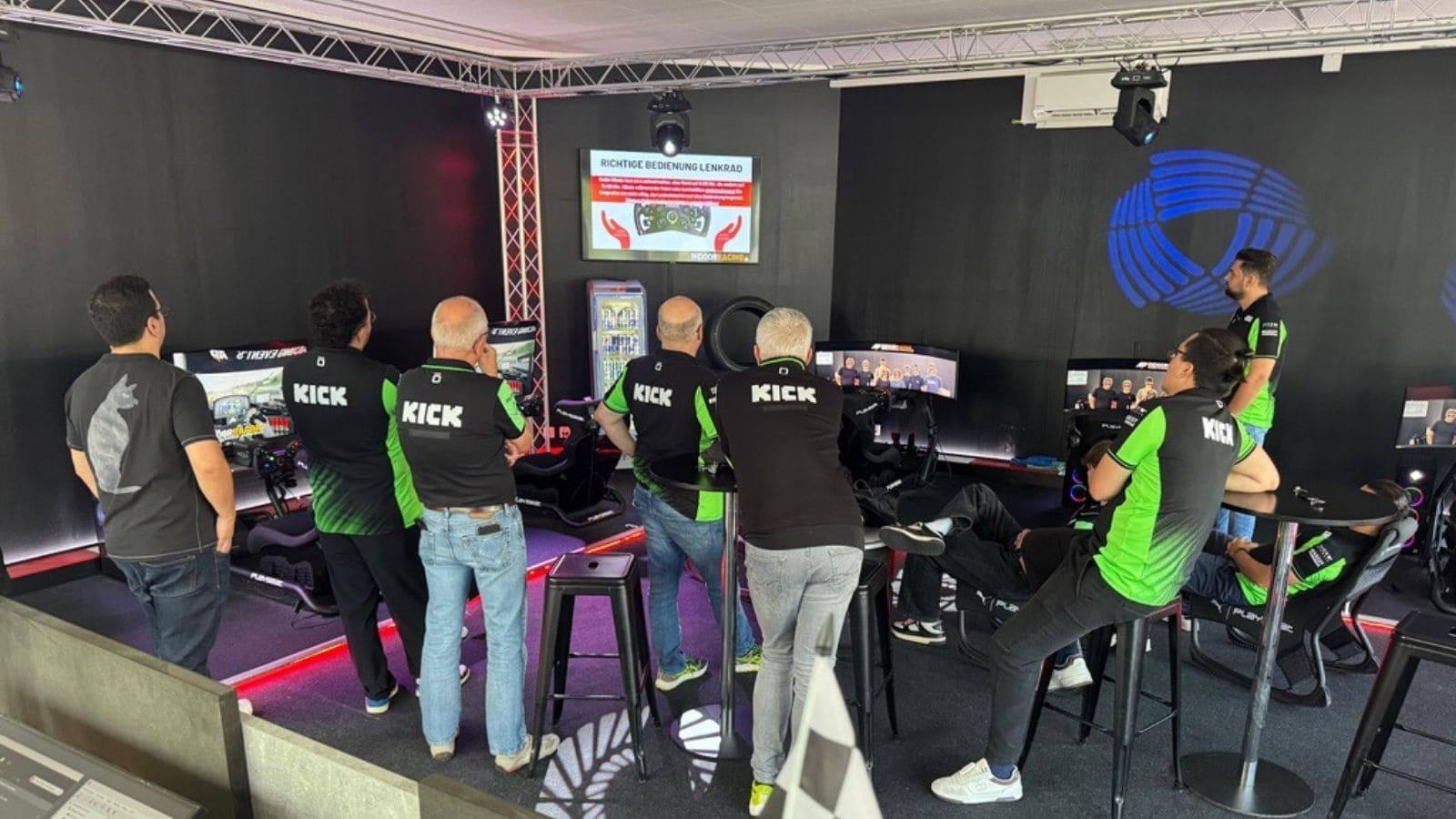 Teilnehmende eines Teamevents bei der Einführung zur Lenkrad-Bedienung vor dem ersten Rennen