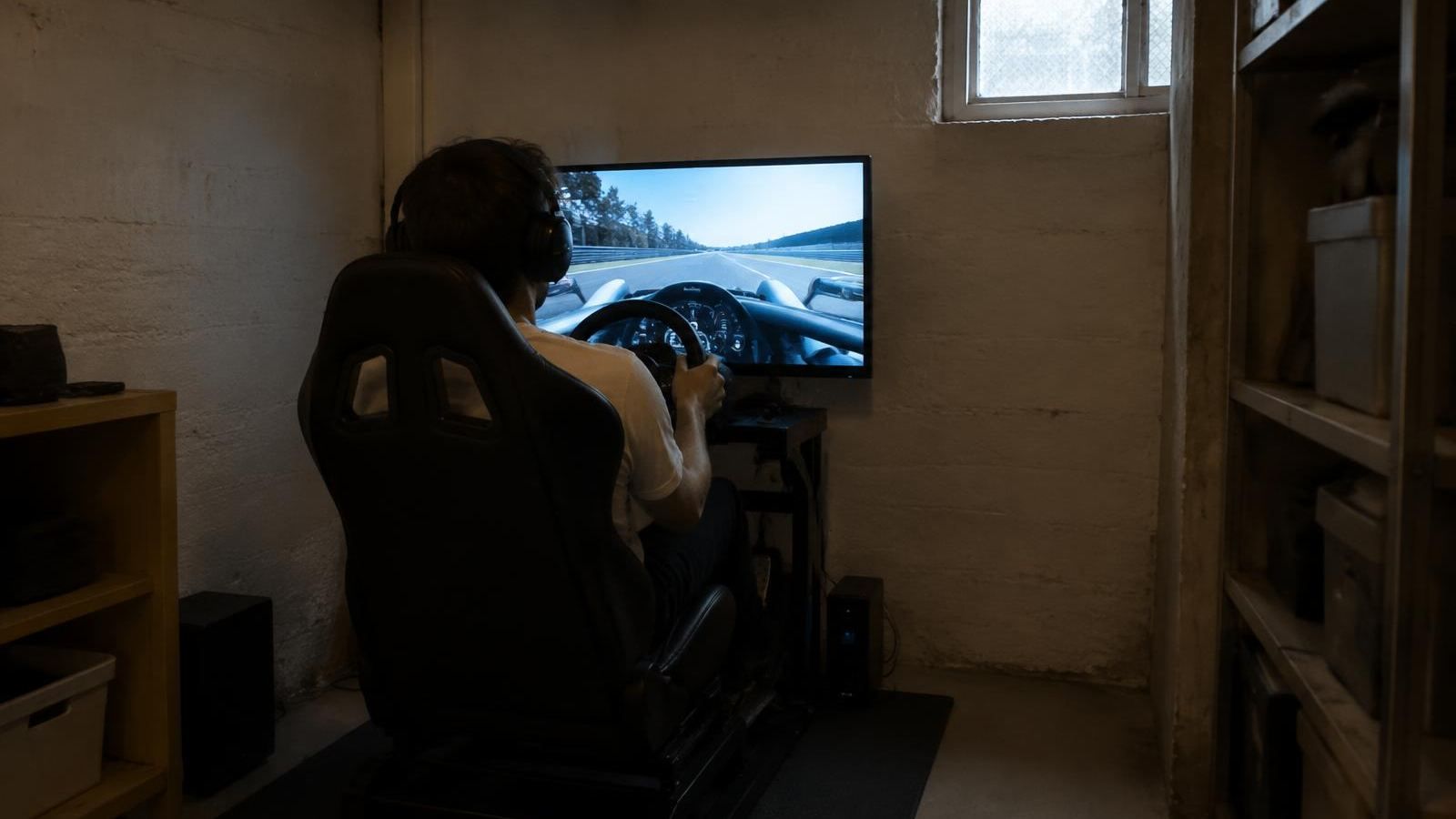Sim-Racing-Cockpit in einem engen Kellerraum, eine Person fährt allein (KI-Symbolbild)