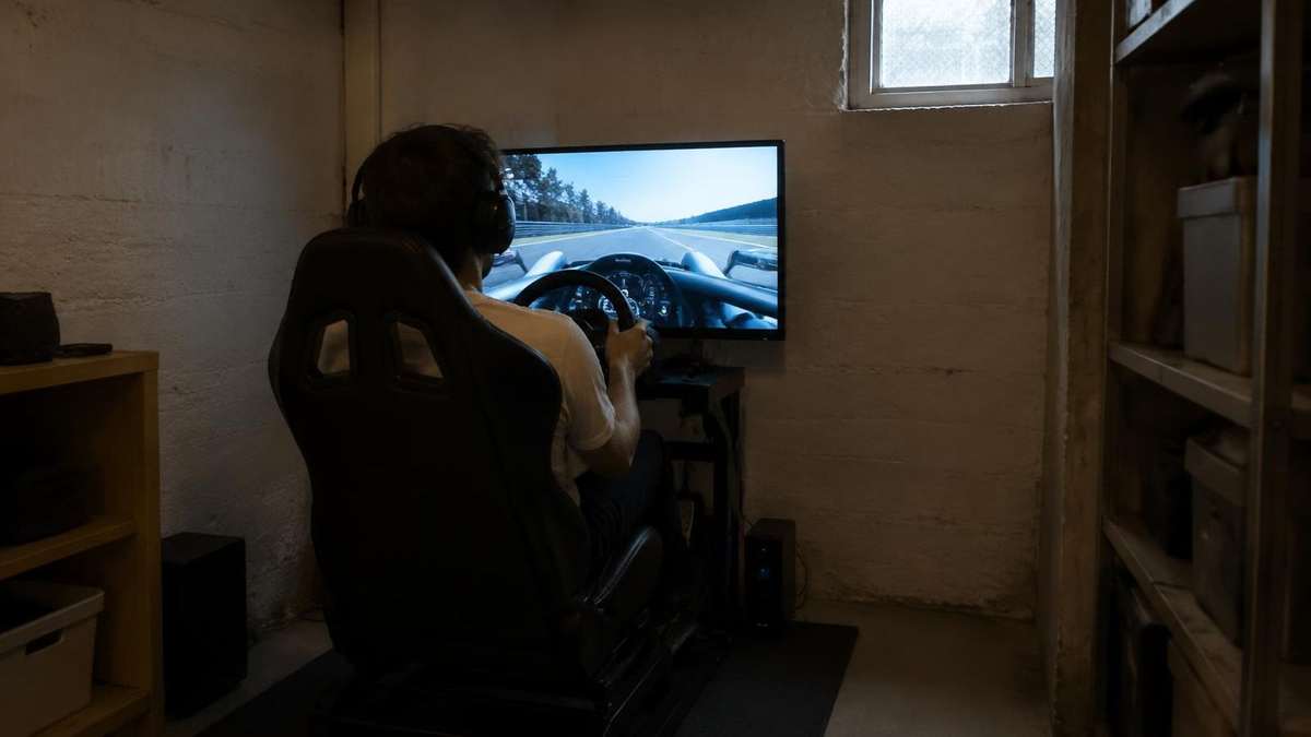 Sim-Racing-Cockpit in einem engen Kellerraum, eine Person fährt allein (KI-Symbolbild)