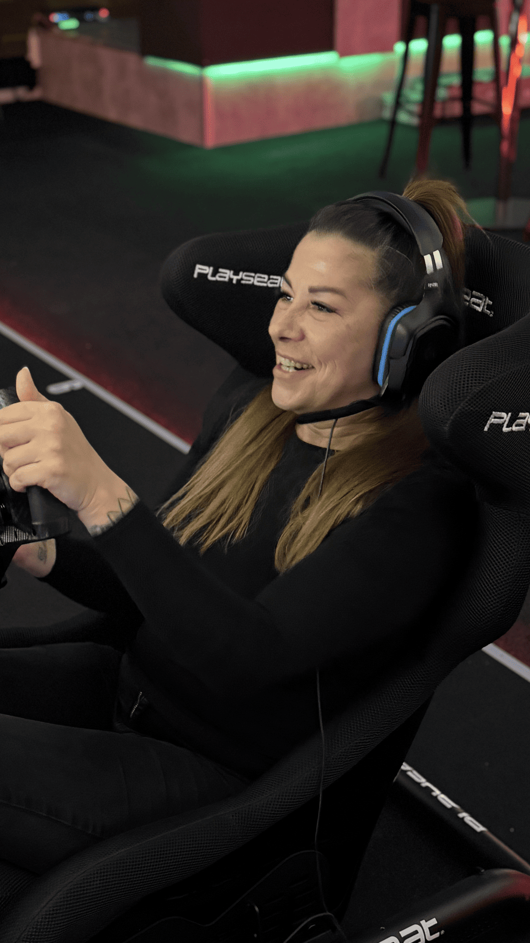 Gruppe lachender Gäste in den Rennsimulatoren im Sim Racing Center Aadorf