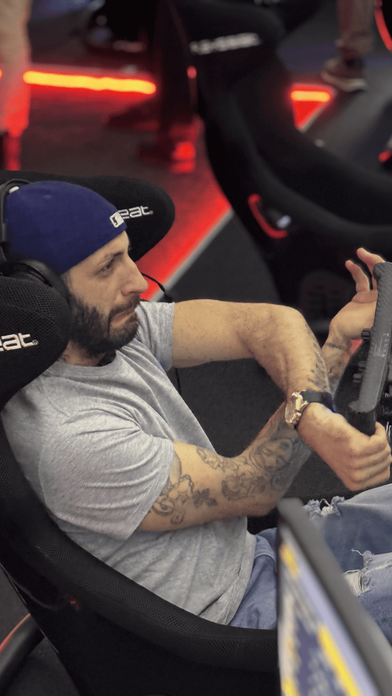 Fahrer im Rennsimulator in einer engen Kurve im Sim Racing Center Aadorf